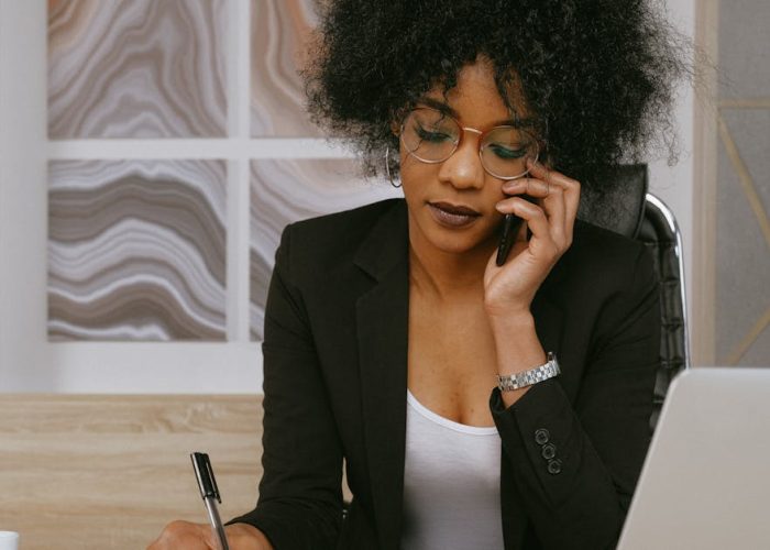 pexels-photo-3727469-3727469-1 Businesswoman making a phone call while working at the desk, focused and professional.